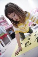 carino poco ragazza a casa pittura con mani foto