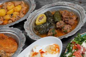eid mubarak tradizionale Ramadan iftar cena. assortito gustoso cibo nel autentico rustico piatti su di legno tavolo sfondo. foto
