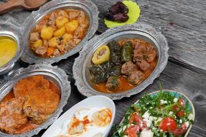 eid mubarak tradizionale Ramadan iftar cena. assortito gustoso cibo nel autentico rustico piatti su di legno tavolo sfondo. foto