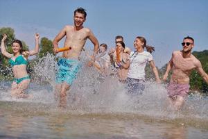 gruppo di contento amici avendo divertimento su fiume foto