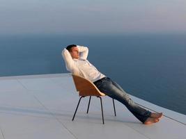 rilassato giovane uomo a casa su balcone foto