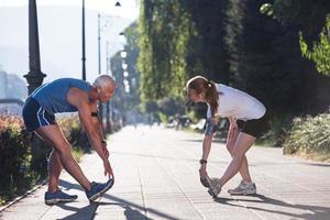 coppia che si riscalda e si allunga prima di fare jogging foto