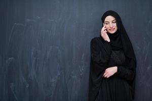 giovane moderno musulmano attività commerciale donna utilizzando smartphone foto