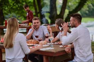 amici avendo picnic francese cena festa all'aperto durante estate vacanza foto