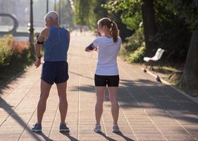 coppia che fa jogging che pianifica il percorso di corsa e imposta la musica foto