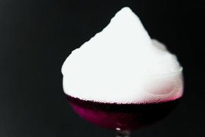 alcolizzato bere. un' cocktail con elite alcool su buio nero sfondo, avvicinamento. foto