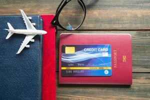 carta di credito messa sul passaporto sulla scrivania di legno foto