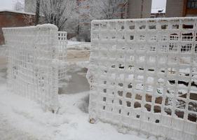 il recinto griglia è disseminato con brina cristalli, fiocchi di neve. inverno nevoso gelido sfondo. mondo neve giorno foto