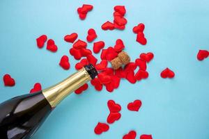 un Aperto bottiglia di Champagne e rosso cuori su un' blu sfondo. vacanza concetto, nuovo anno, San Valentino giorno, marzo 8 foto