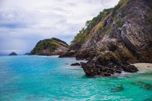 blu verde oceano con roccia montagna nel pieno di nuvole giorno. vista sul mare e naturale sfondo. foto