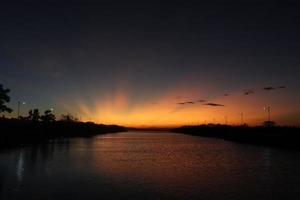 cielo drammatico colorato con nuvole al tramonto. tramonto nel lago foto