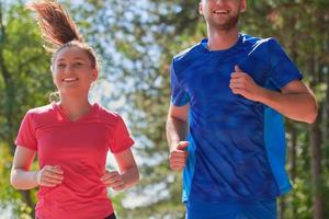 coppia godendo nel un' salutare stile di vita mentre jogging su un' nazione strada foto