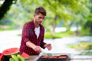 uomo cucinando gustoso cibo su barbecue griglia foto