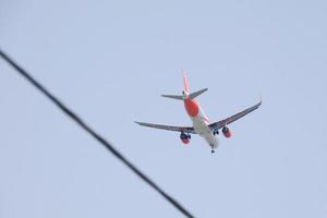 commerciale aereo volante sotto blu cieli e in arrivo a il aeroporto foto