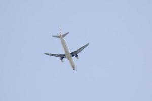 commerciale aereo volante sotto blu cieli e in arrivo a il aeroporto foto