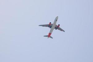 commerciale aereo volante sotto blu cieli e in arrivo a il aeroporto foto