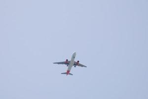 commerciale aereo volante sotto blu cieli e in arrivo a il aeroporto foto