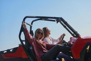 ragazze godendo un' bellissimo soleggiato giorno mentre guida un fuori strada auto foto