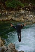 uomo salto nel selvaggio fiume foto