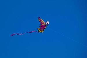 colorato aquilone volante sotto il blu cielo foto