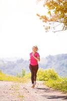 donna jogging su soleggiato giorno a natura foto