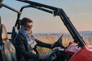 uomo godendo bellissimo soleggiato giorno mentre guida un' via strada passeggino auto foto