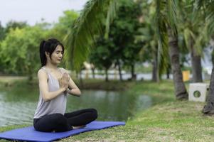 ritratto di giovane asiatico donna giocare yoga nel il pubblico parco foto