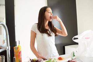 giovane donna che cucina in cucina foto