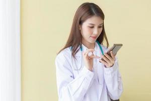 medico femminile asiatico che utilizza un telefono cellulare foto