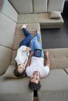 coppia a moderno casa utilizzando tavoletta computer foto