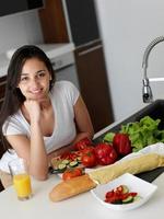 giovane donna che cucina in cucina foto