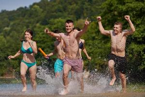 gruppo di contento amici avendo divertimento su fiume foto