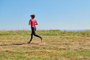 donna godendo nel un' salutare stile di vita mentre jogging foto