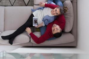 coppia che si rilassa a casa con i tablet foto
