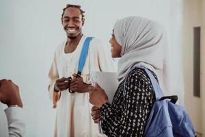 gruppo di contento africano studenti avendo conversazione e squadra incontro Lavorando insieme su compiti a casa ragazze indossare tradizionale Sudan musulmano hijab moda foto