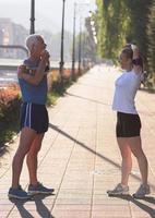 coppia che si riscalda e si allunga prima di fare jogging foto