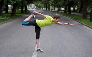 femmina corridore riscaldamento su e allungamento prima mattina formazione foto