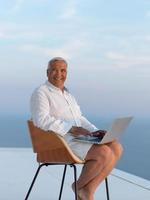 rilassato anziano uomo su balcone foto