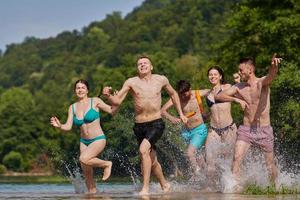 gruppo di contento amici avendo divertimento su fiume foto