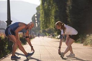 coppia che si riscalda e si allunga prima di fare jogging foto