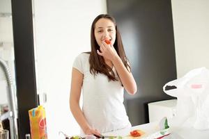 giovane donna che cucina in cucina foto