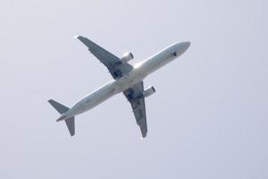 commerciale aereo volante sotto blu cieli e in arrivo a il aeroporto foto