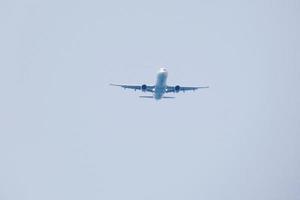 commerciale aereo volante sotto blu cieli e in arrivo a il aeroporto foto