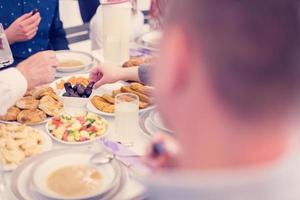 moderno multietnico musulmano famiglia condivisione un' ciotola di date foto