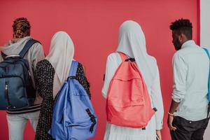 un' gruppo di africano musulmano studenti con zaini in posa su un' rosa sfondo. il concetto di scuola formazione scolastica. foto