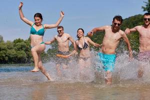 gruppo di contento amici avendo divertimento su fiume foto