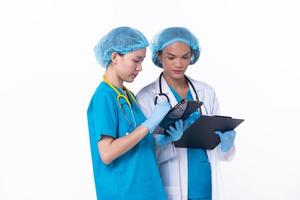 pieno lunghezza professionale medico medico In piedi nel ospedale uniforme discutere paziente grafico condizione su tavoletta. donna professionista indossare cappotto fiducioso nel clinica, isolato bianca sfondo foto