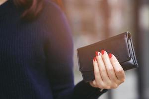 donna persona Tenere un' portafoglio nel il mano. costo controllo spese shopping nel concetto. partire spazio per Scrivi descrittivo testo foto