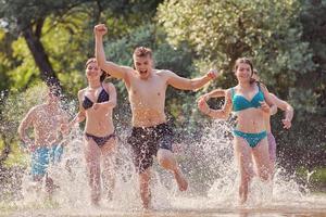 gruppo di contento amici avendo divertimento su fiume foto