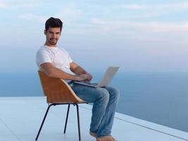 rilassato giovane uomo a casa su balcone foto